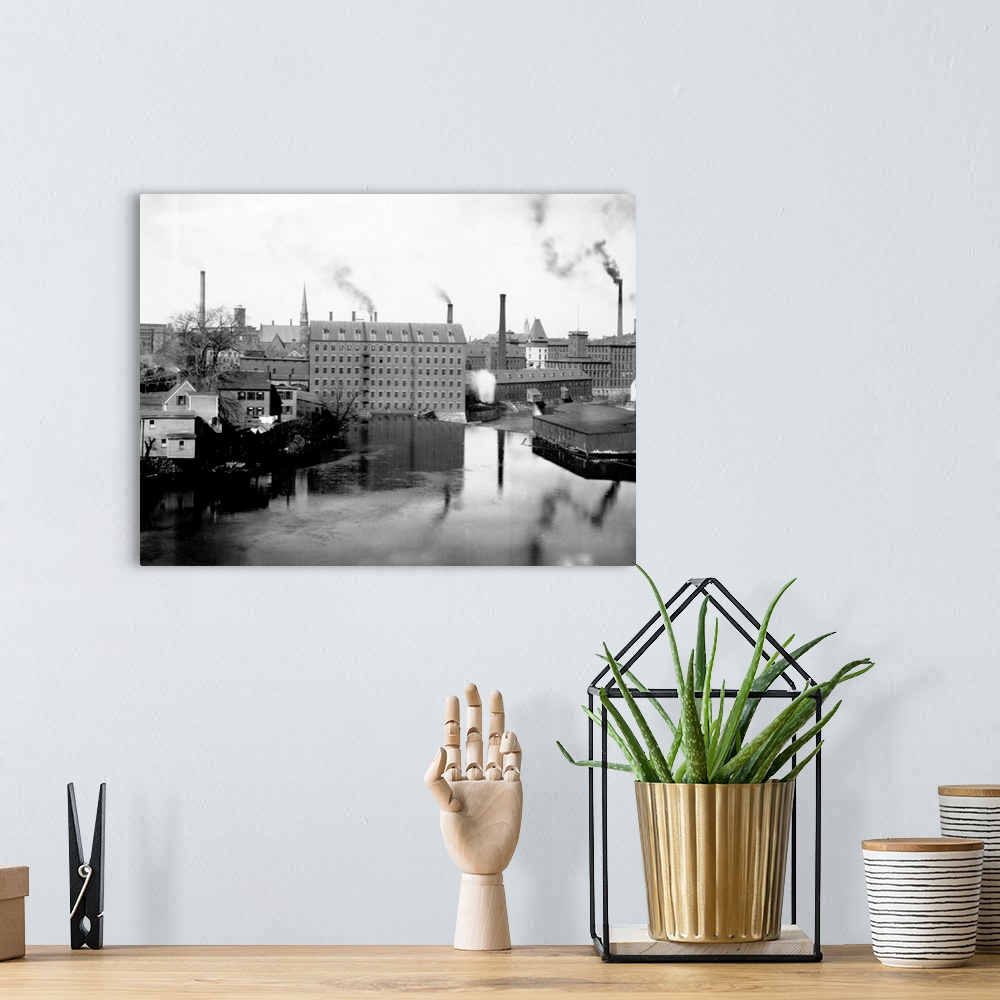 A bohemian room featuring Mills and smokestacks line the Merrimack River in Lowell, Massachusetts.