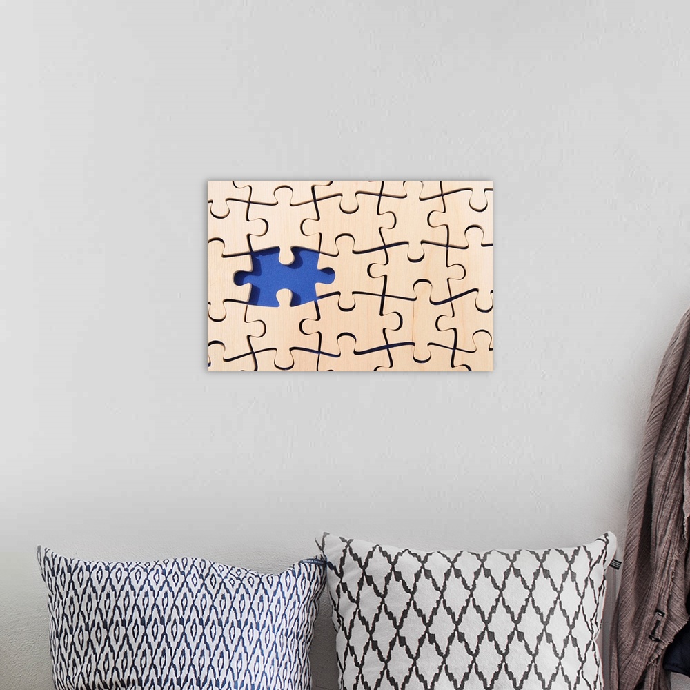 A bohemian room featuring Large canvas photo of puzzle pieces placed together with one piece missing.
