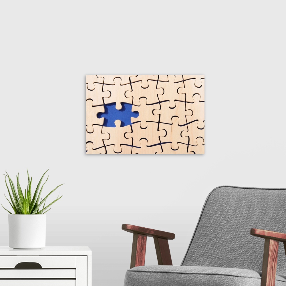 A modern room featuring Large canvas photo of puzzle pieces placed together with one piece missing.