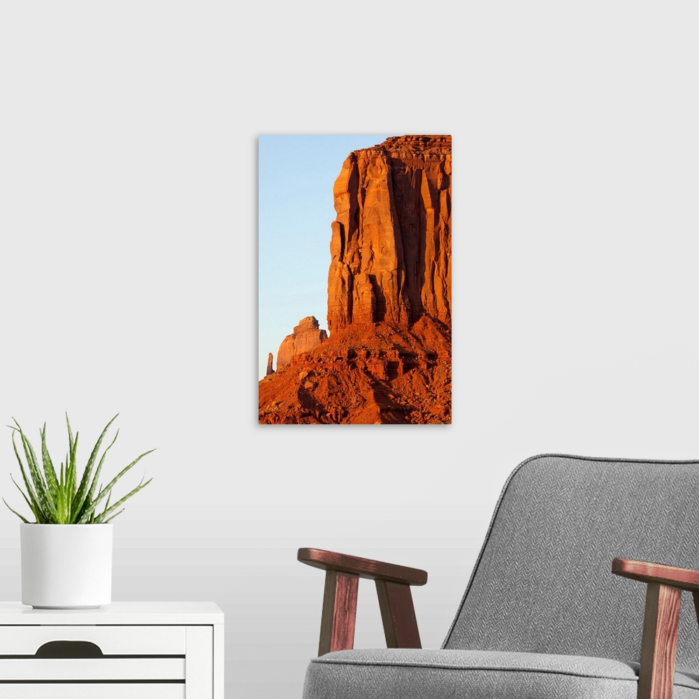 A modern room featuring Setting sun lights red sandstone rock cliffs of The Mittens in Monument Valley. | Location: Monum...