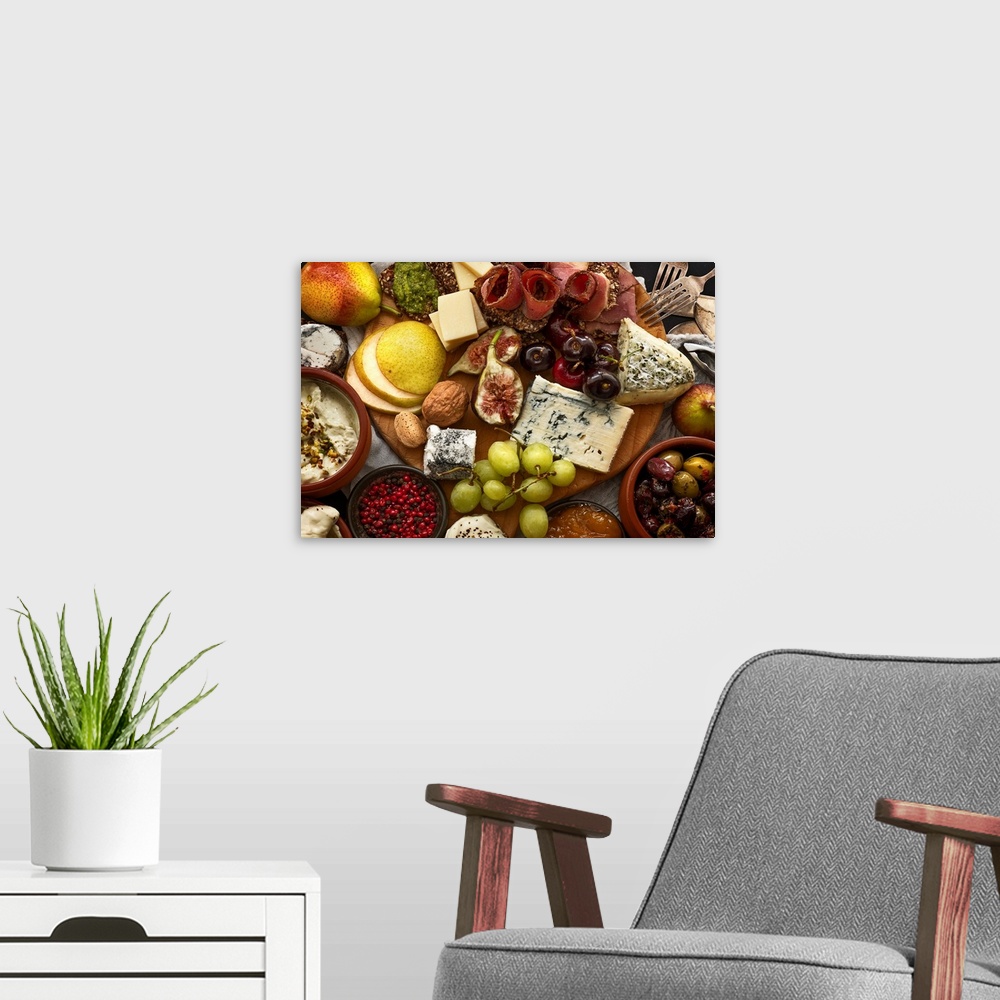 A modern room featuring Mix of antipasti cheese, prosciutto, and fruits on platter. Large plate filled with appetisers af...