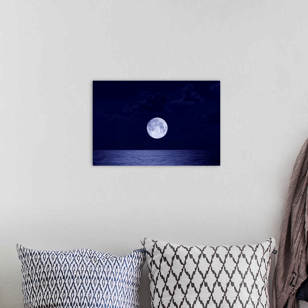 A bohemian room featuring This is a landscape photograph of the moon, larger than usual due to distortion, rising over the ...