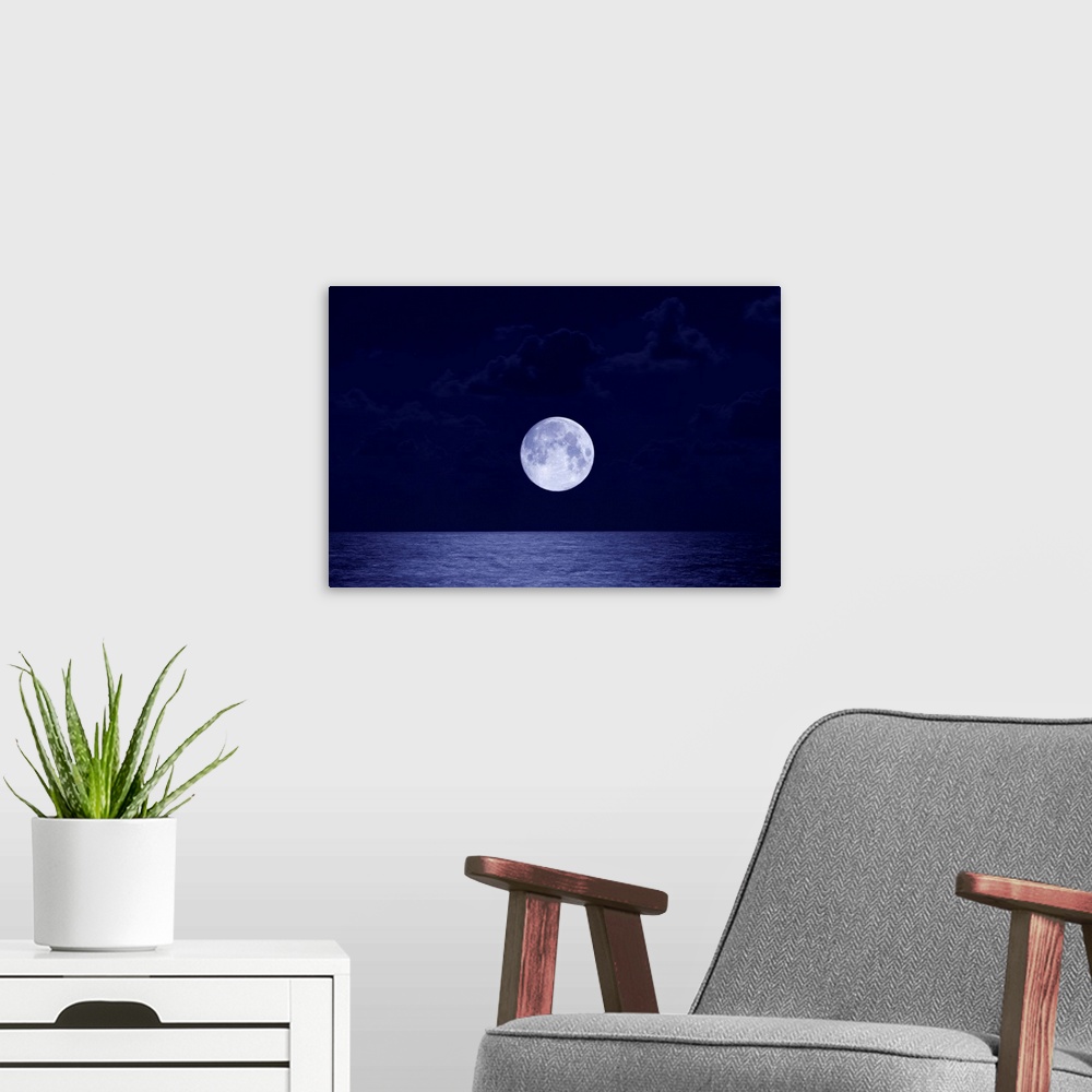 A modern room featuring This is a landscape photograph of the moon, larger than usual due to distortion, rising over the ...