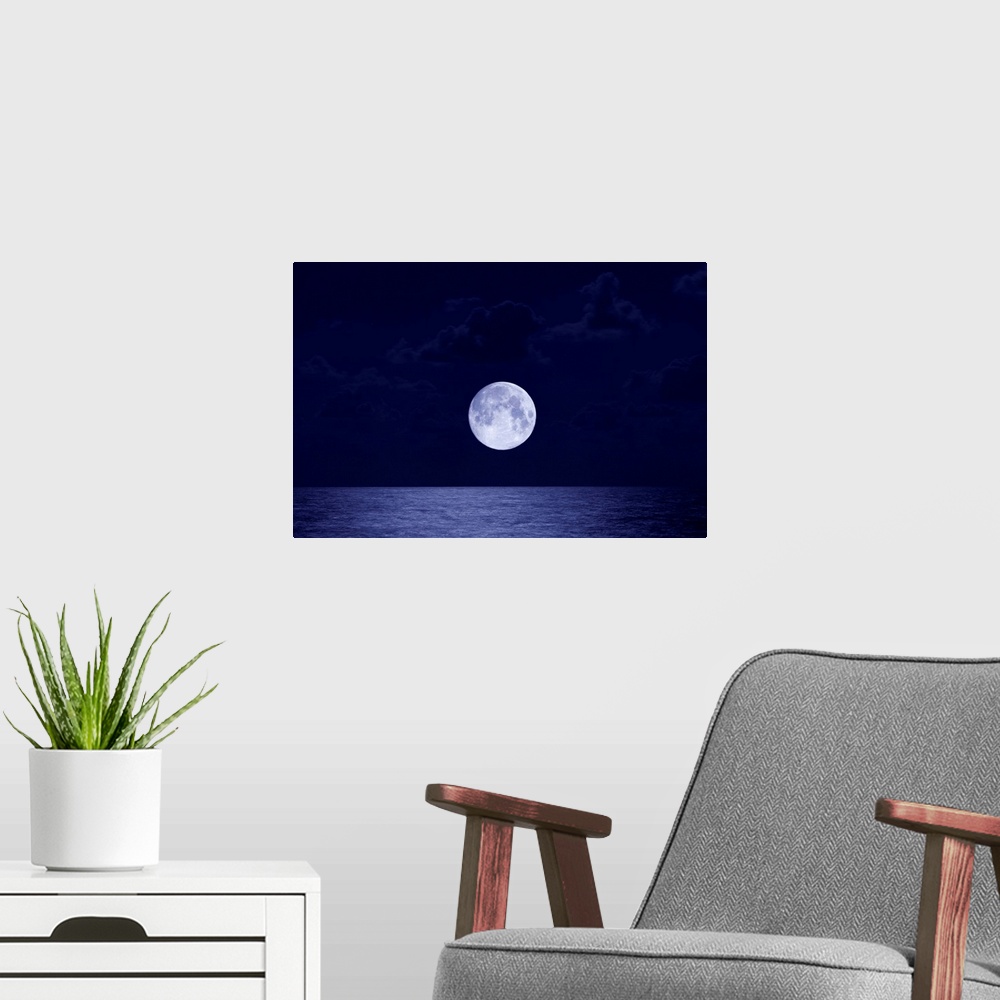 A modern room featuring This is a landscape photograph of the moon, larger than usual due to distortion, rising over the ...