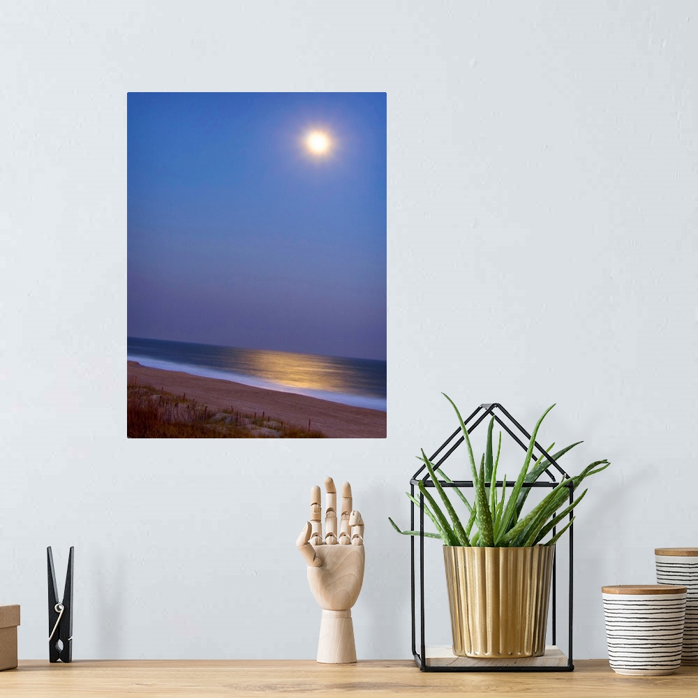 A bohemian room featuring This large piece is a picture of the moon shining brightly over the beach and reflecting in the o...