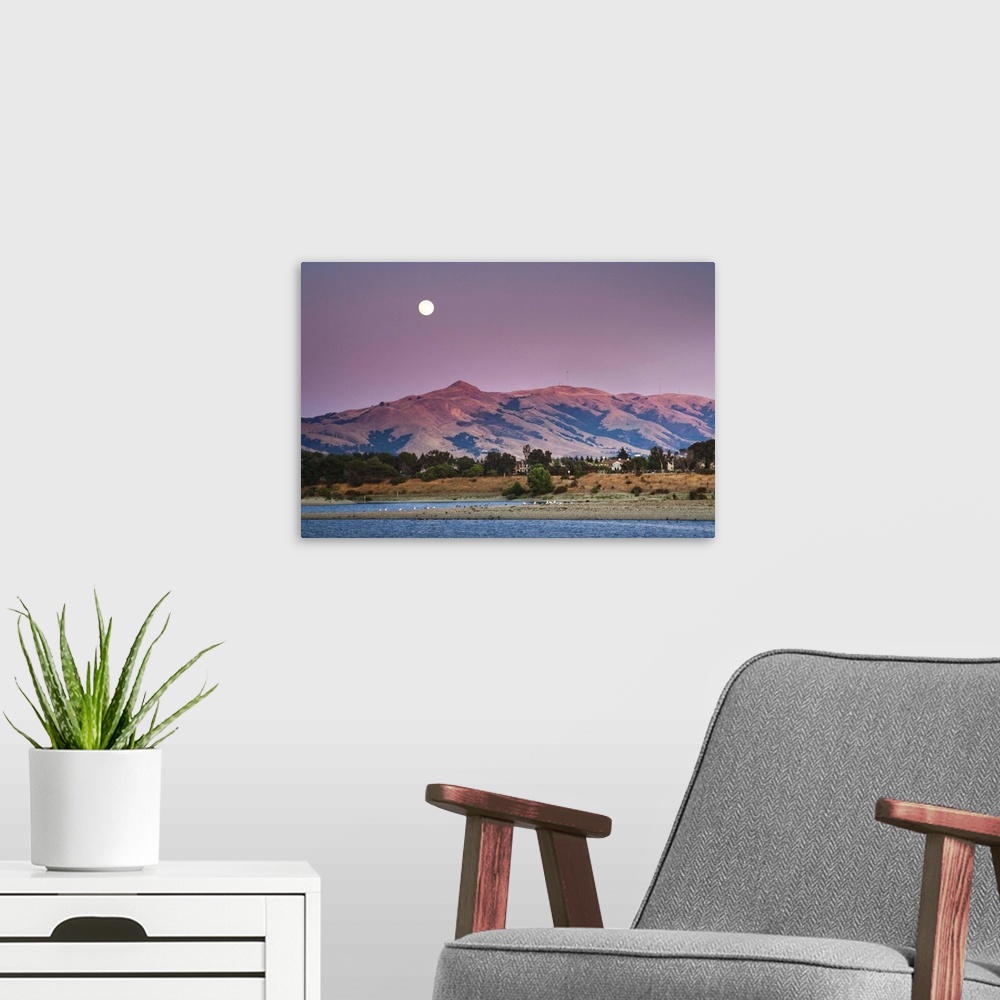 A modern room featuring Moonrise Over Mission peak California at sunset time.