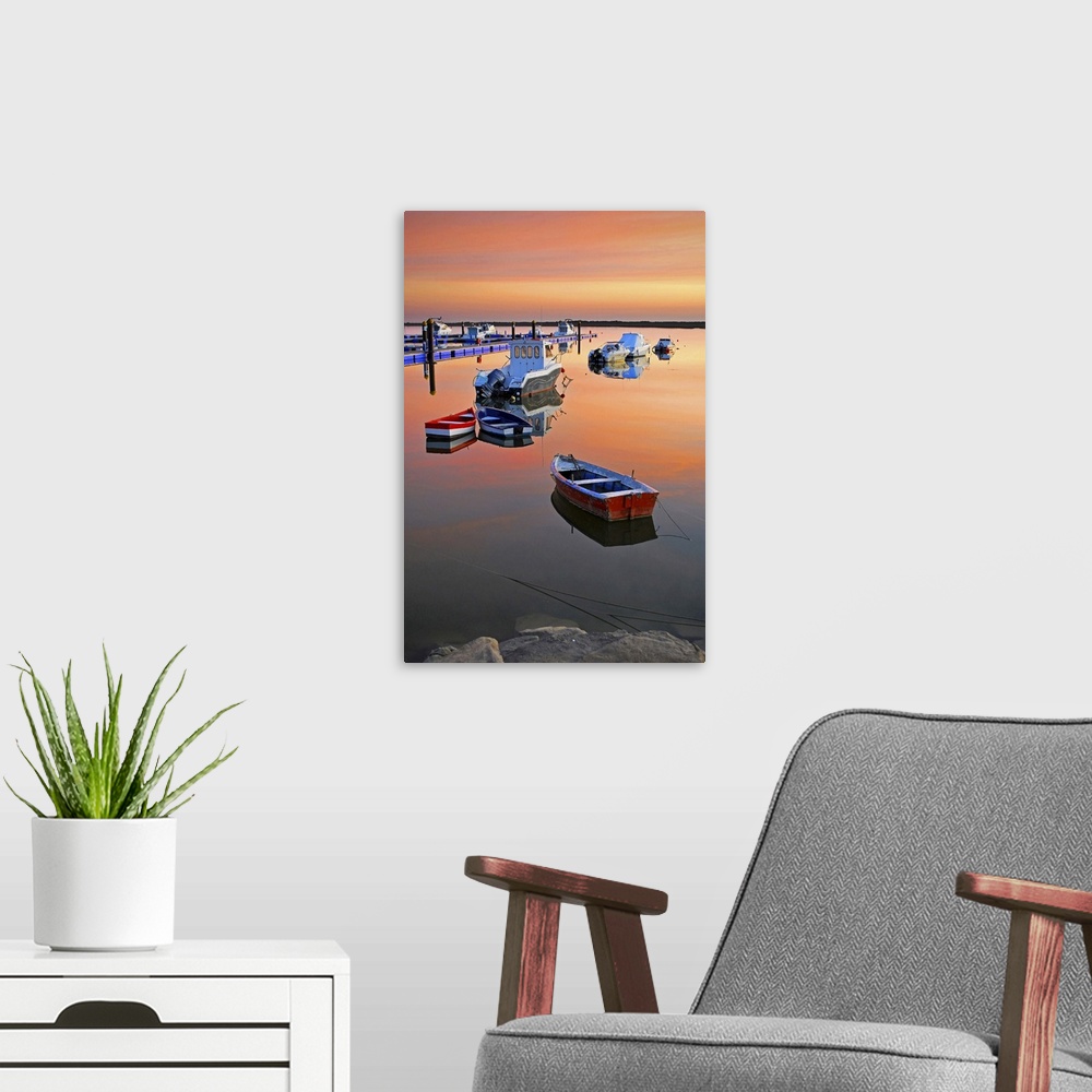 A modern room featuring Moored boats on sea at sunset.