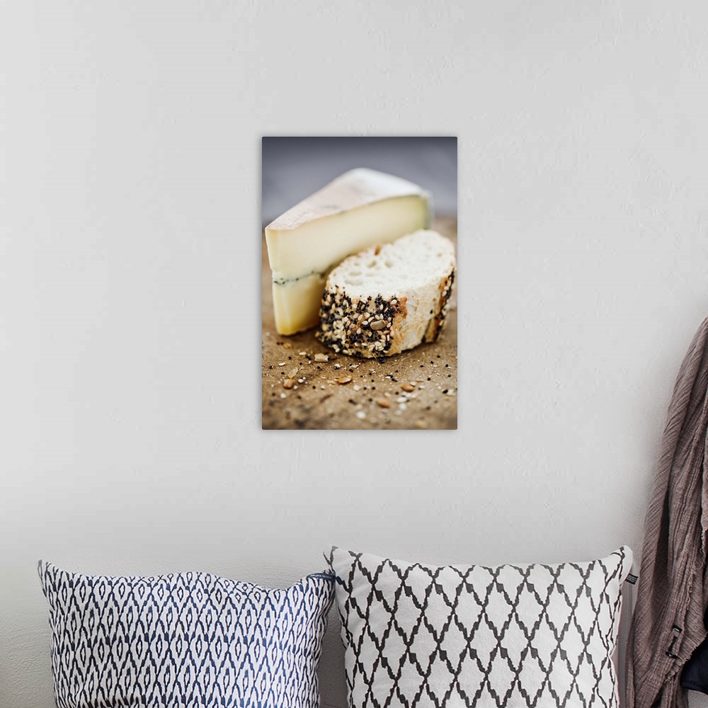 A bohemian room featuring Morbier cheese on a board with seeded bread.