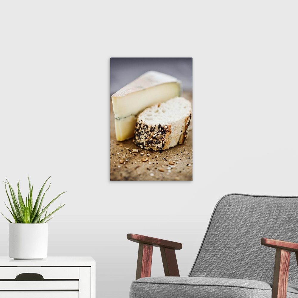 A modern room featuring Morbier cheese on a board with seeded bread.