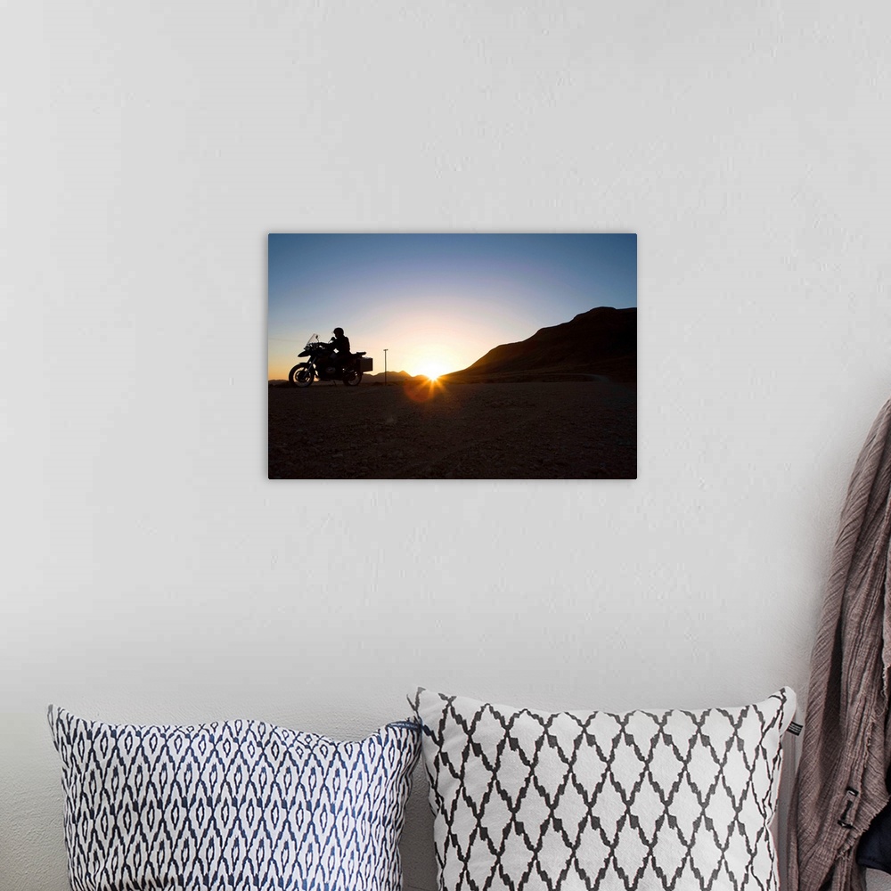 A bohemian room featuring Motorcyclist riding at sunset