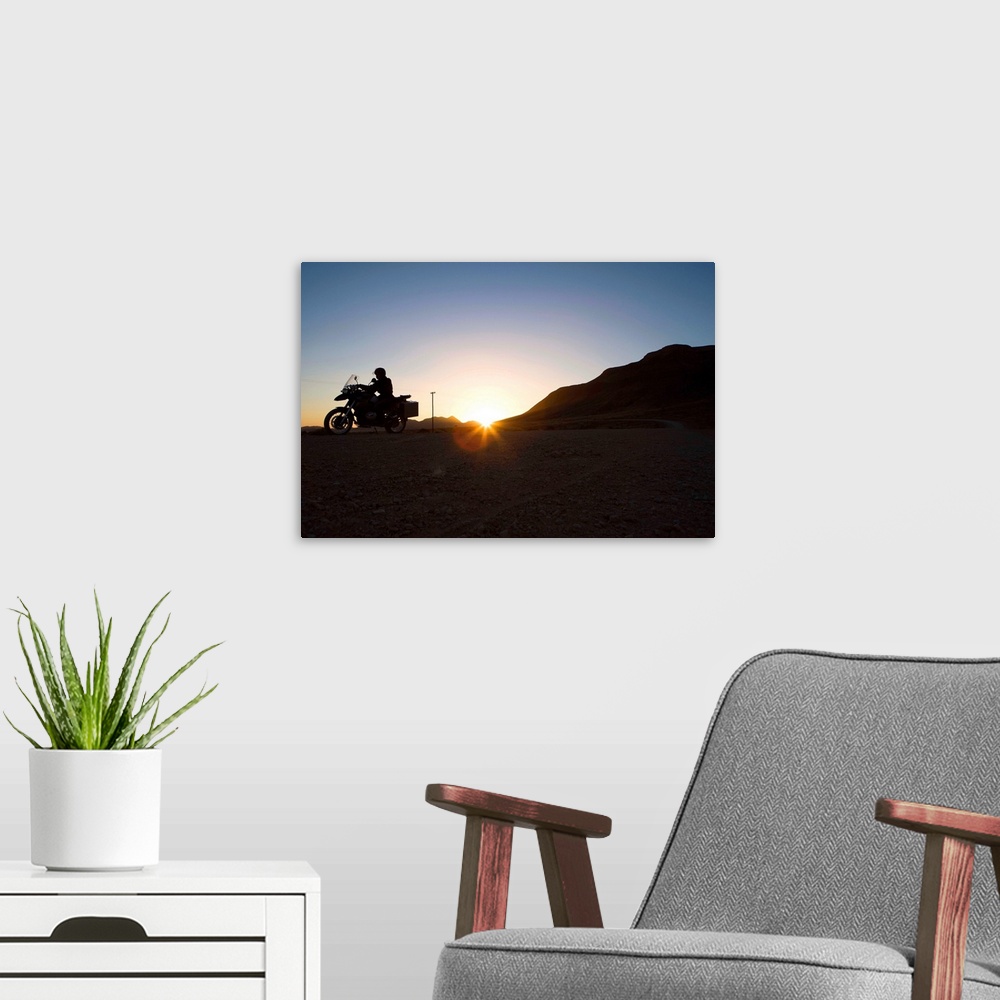 A modern room featuring Motorcyclist riding at sunset