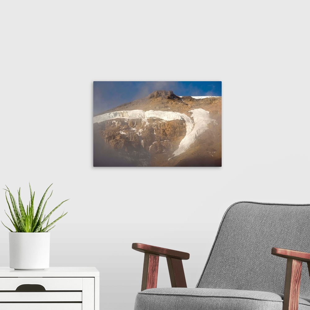 A modern room featuring Setting sun lights cliffs and glaciers of Mount Kilimanjaro, viewed from Lava Tower (15100').