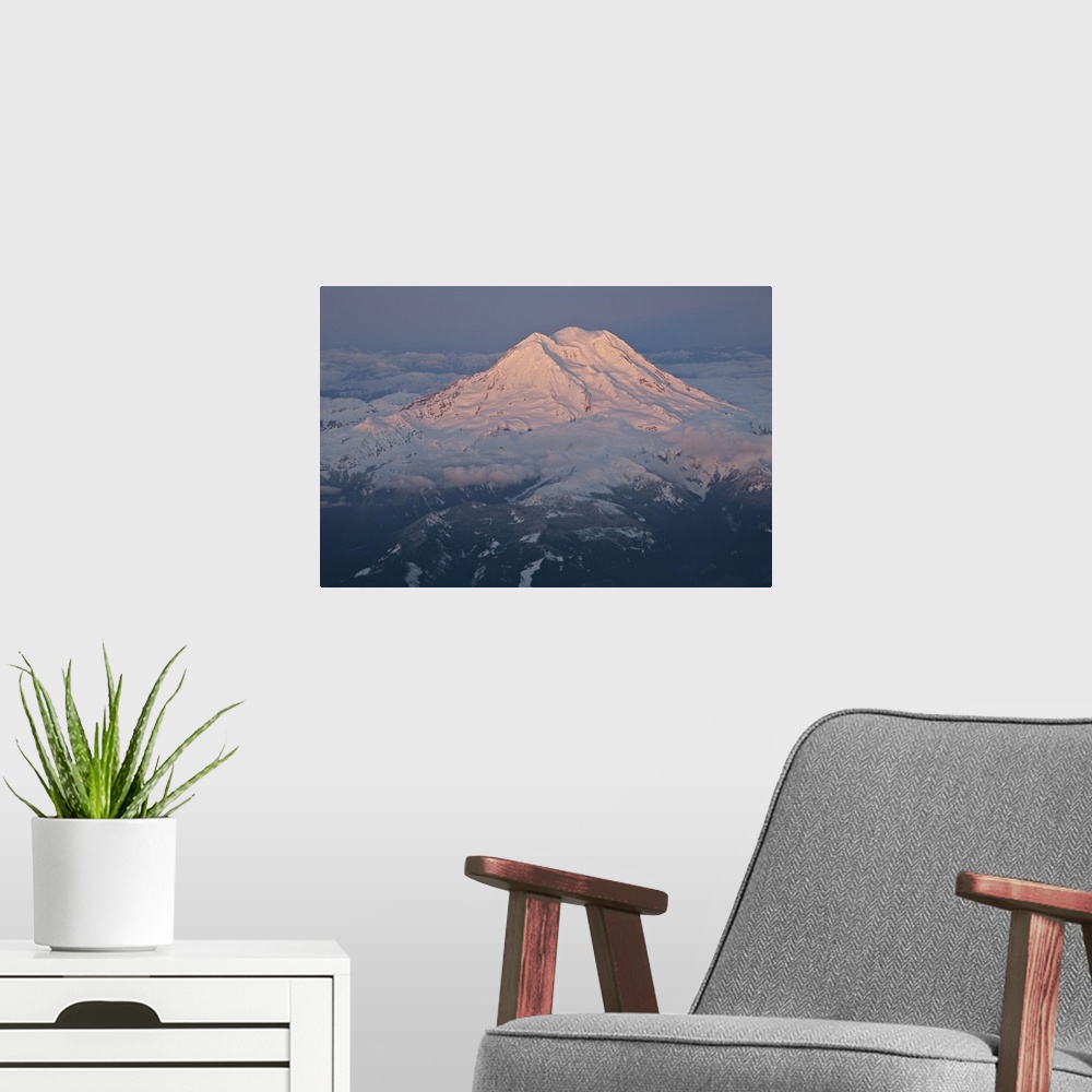 A modern room featuring Landscape, aerial photograph of a snow covered Mount Rainier, surrounded by clouds, a dark sky in...