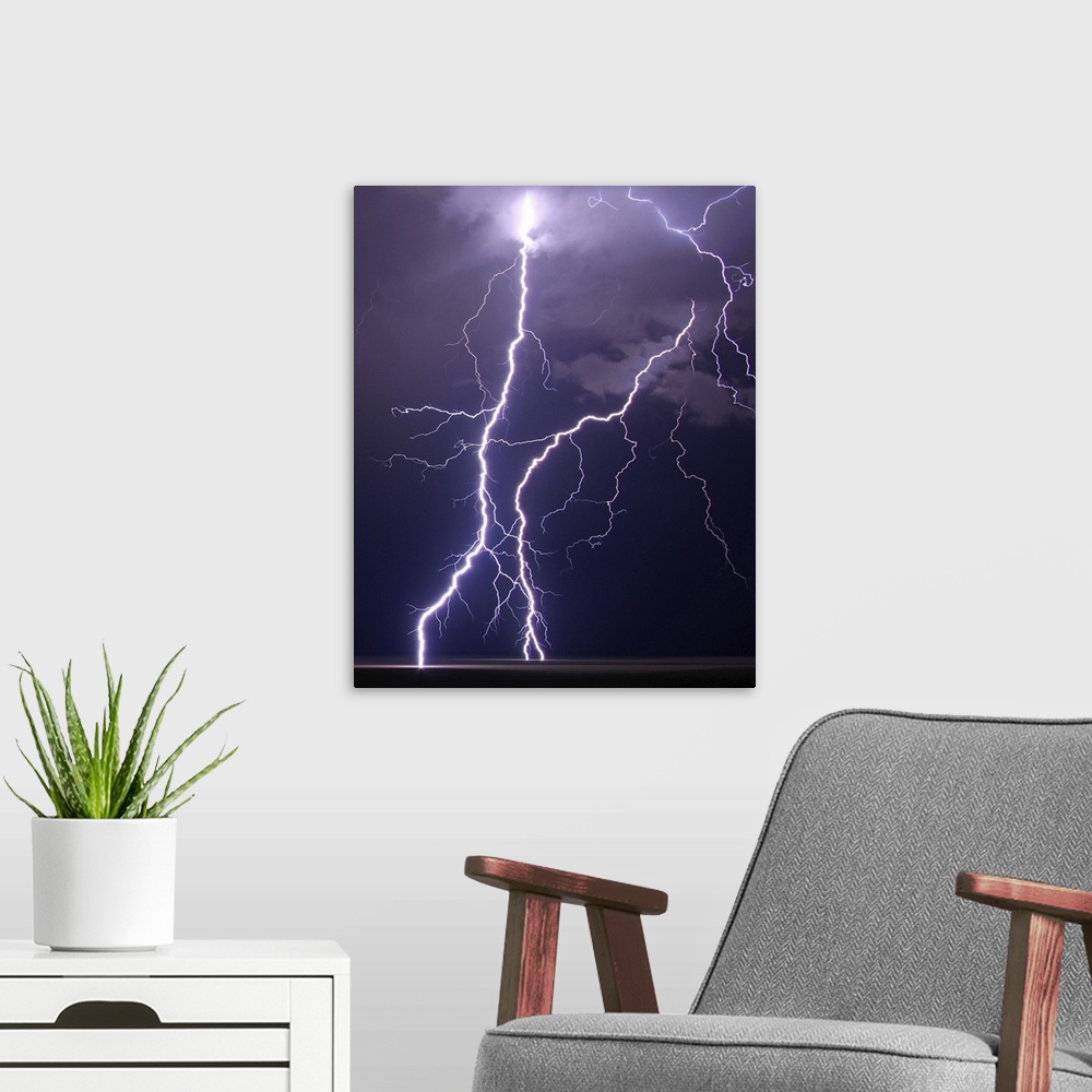 A modern room featuring Multiple cloud to ground lightning strikes fill frame on this shot of summer night's storm over p...