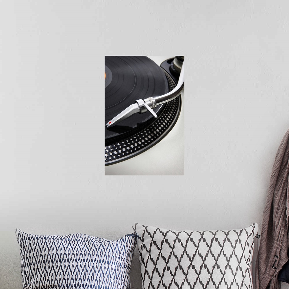 A bohemian room featuring A Record needle stylus on a record deck playing a record
