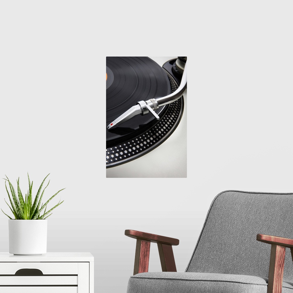A modern room featuring A Record needle stylus on a record deck playing a record