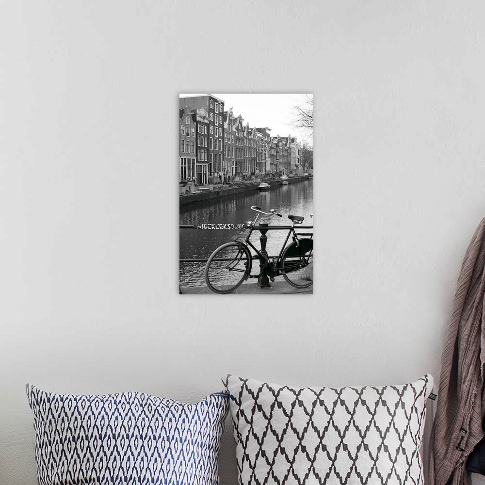 A bohemian room featuring Vertical canvas photo art of a bike leaning against a railing in front of a river running through...