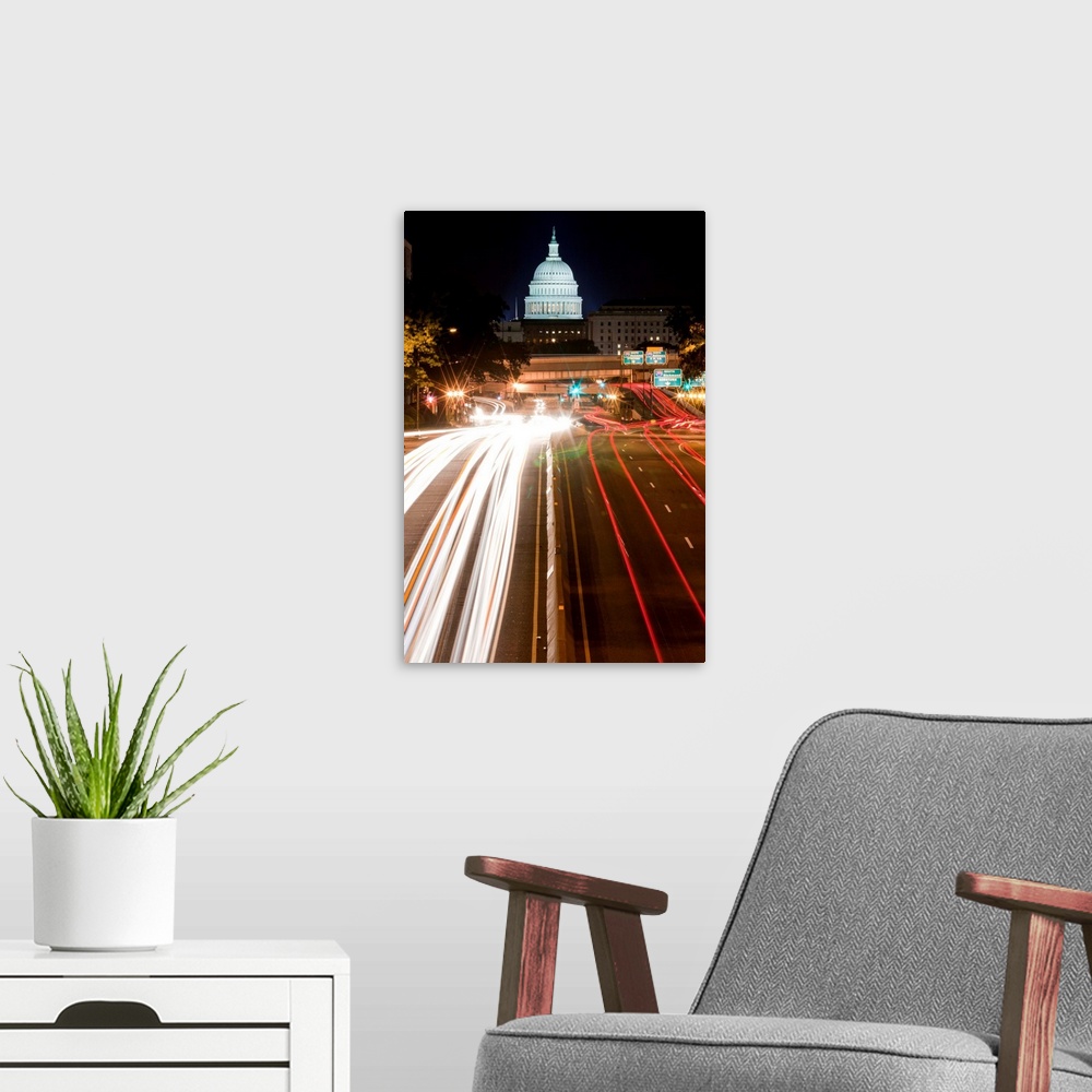 A modern room featuring U. S. Capitol Building looms above traffic along New York Avenue on summer evening, Washington, DC.