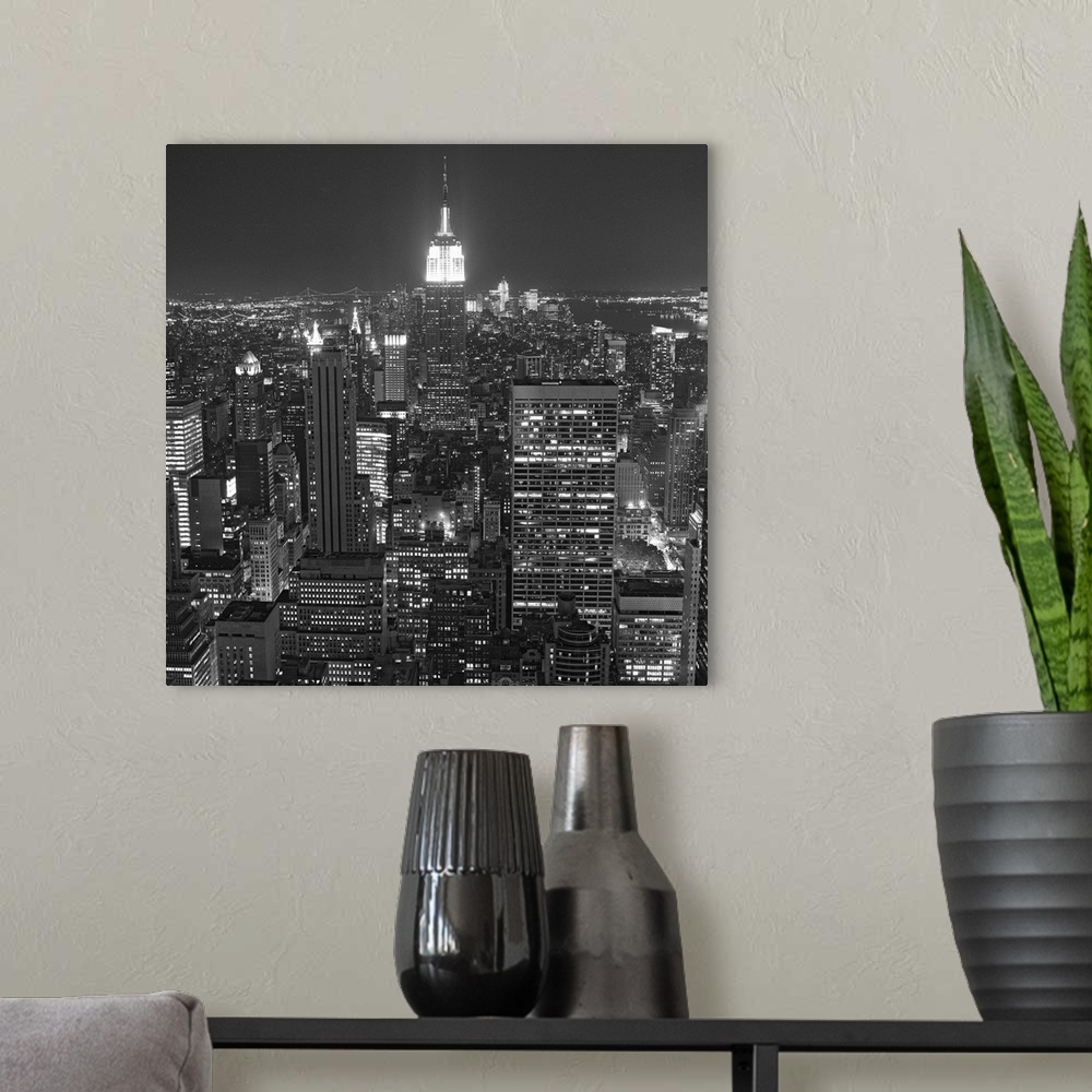 A modern room featuring Photograph of skyscrapers and skyline lit up after dark in the "Big Apple."
