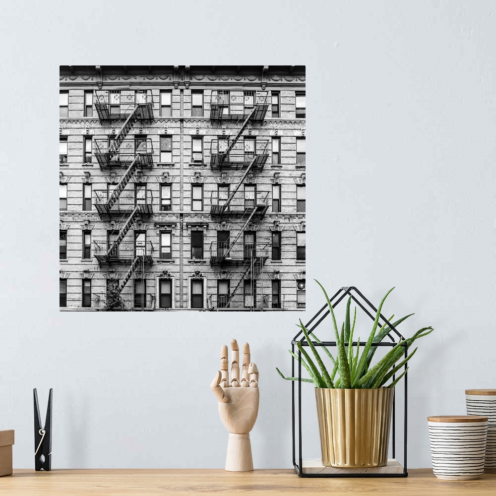 A bohemian room featuring A fire escape of an apartment building in New York city. Graphic black and white image.