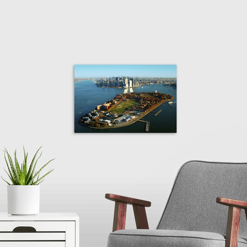A modern room featuring New York Harbor and Manhattan  with Governors Island in the foreground.