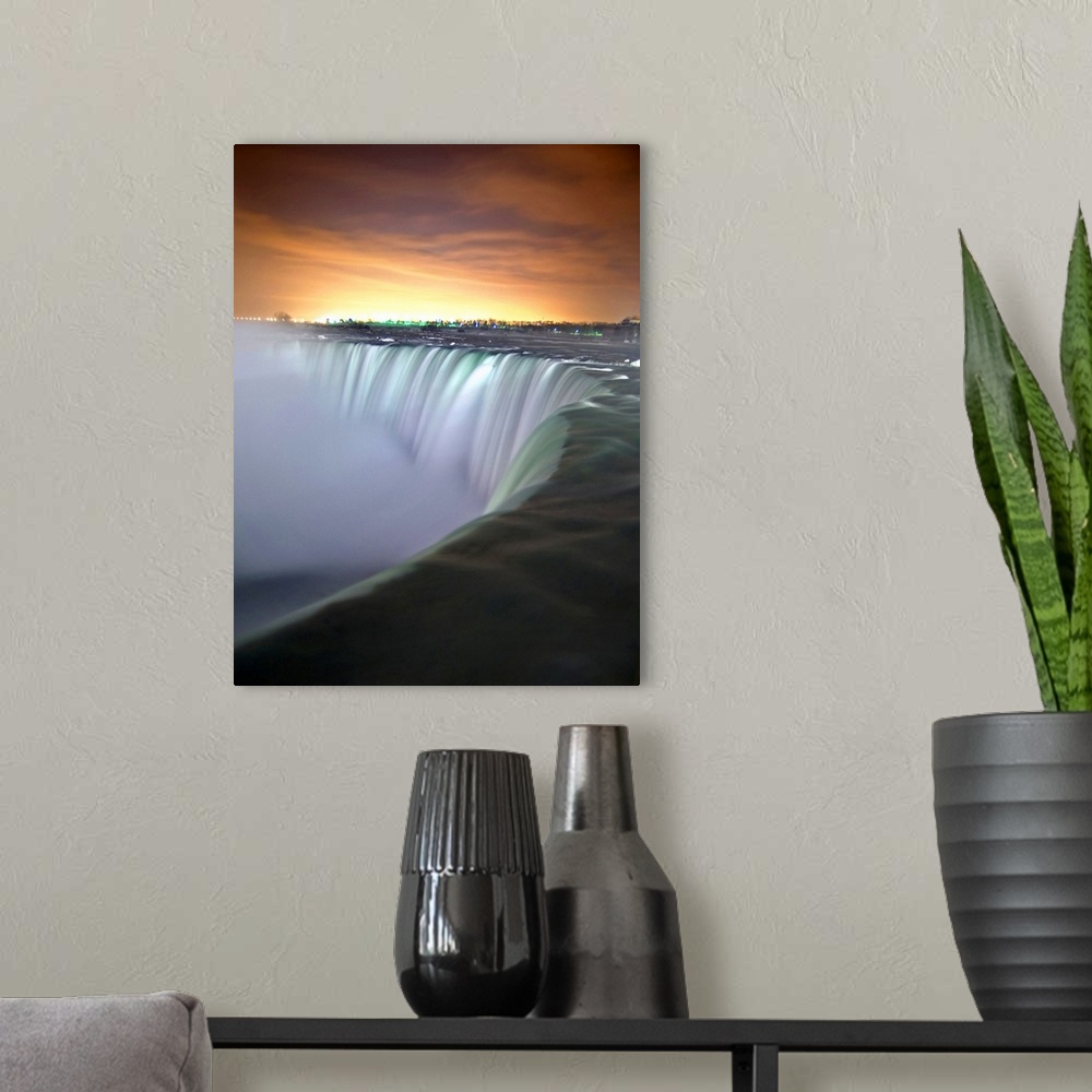 A modern room featuring This vertical photograph captures the growing light in the eastern horizon and the massive cascad...