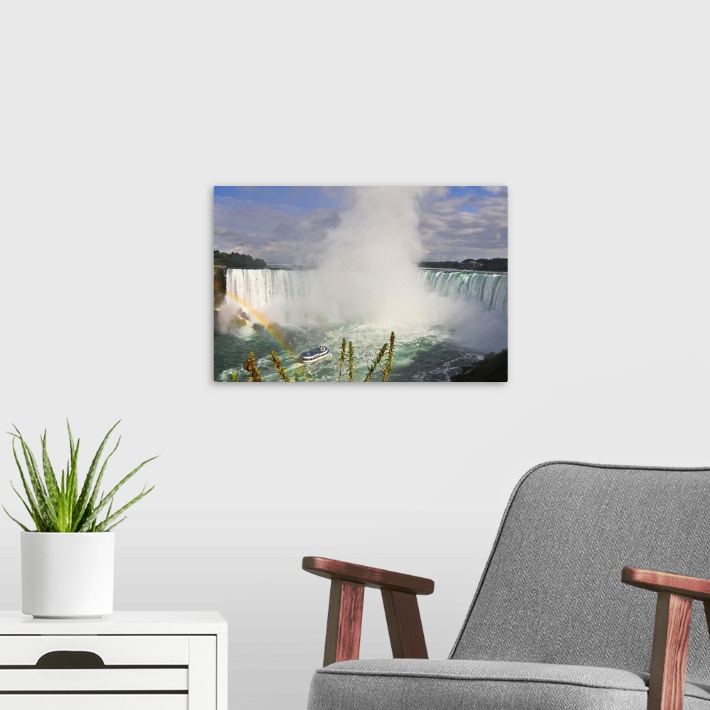 A modern room featuring Wide landscape view of waterfall Rainbow in foreground Turquoise color of water Blue sky and whit...