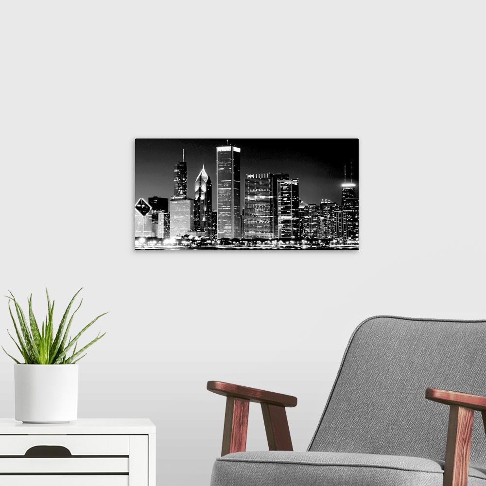 A modern room featuring This high contrast landscape photograph shows the illuminated nightscape of this city skyline.
