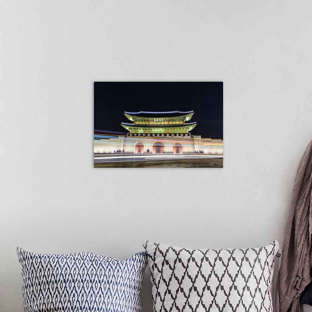 A bohemian room featuring Night view of Gyeongbokgung palace with lights trails on road in Seoul, South Korea.