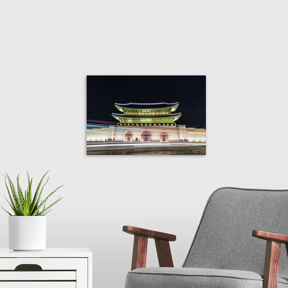 A modern room featuring Night view of Gyeongbokgung palace with lights trails on road in Seoul, South Korea.