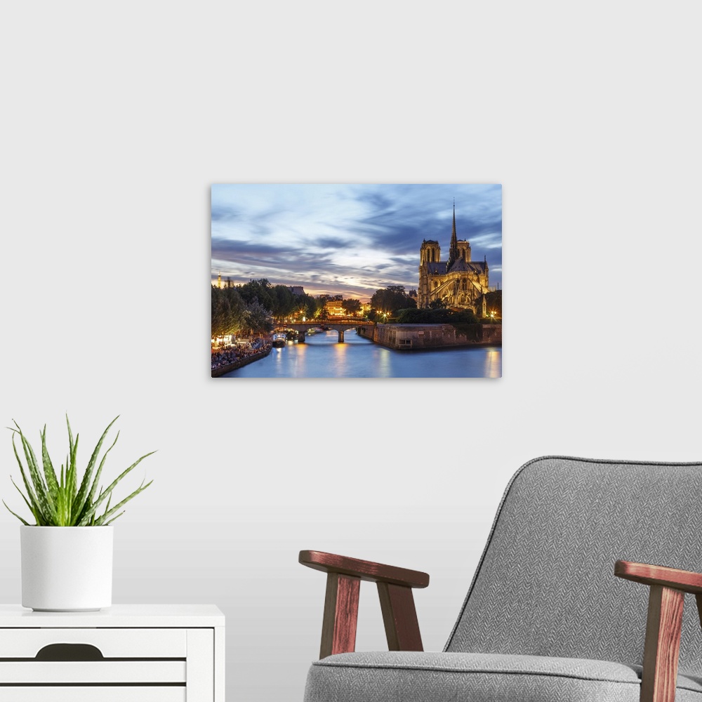 A modern room featuring View of Notre Dame and Seine river at dusk in Paris.