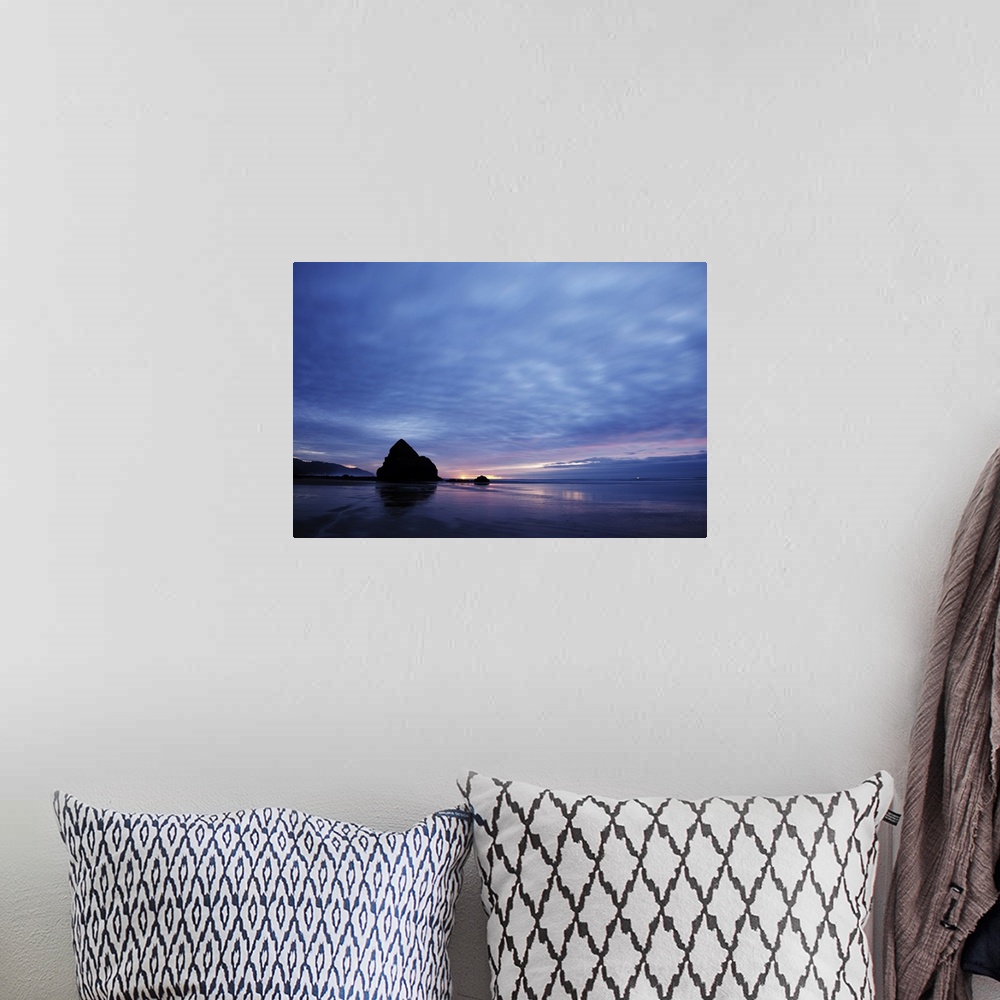 A bohemian room featuring Pacific ocean, Cannon Beach, OR after the sunset. Small yellow light on the horizon is a lighthou...