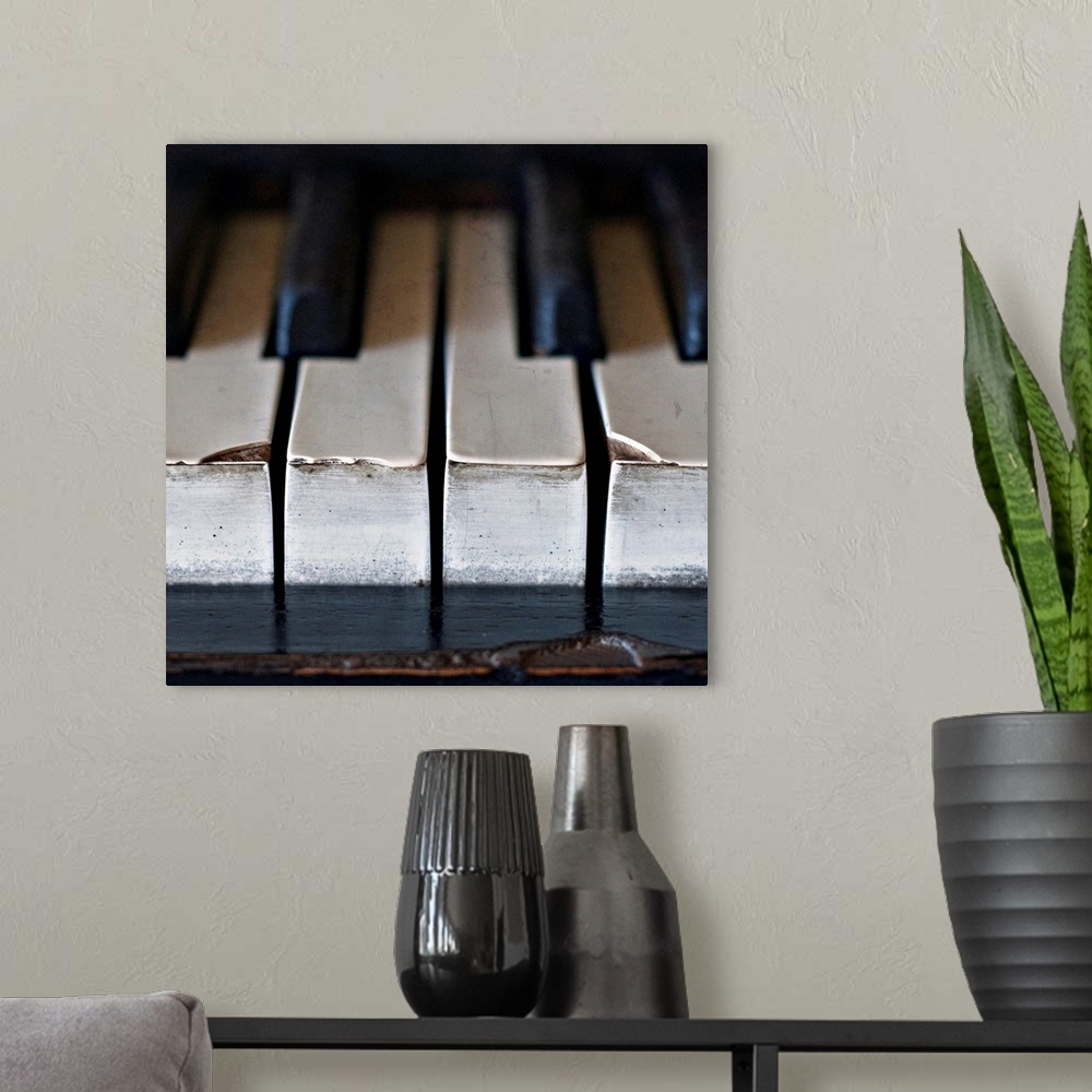 A modern room featuring Old, antique upright piano keys displaying wear and tear.