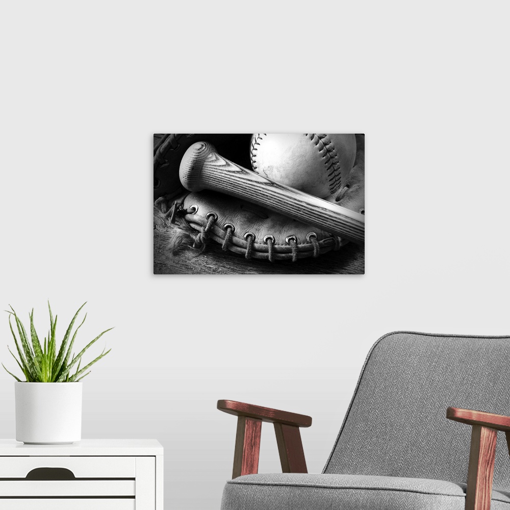 A modern room featuring A black and white image of an old baseball glove and bat.