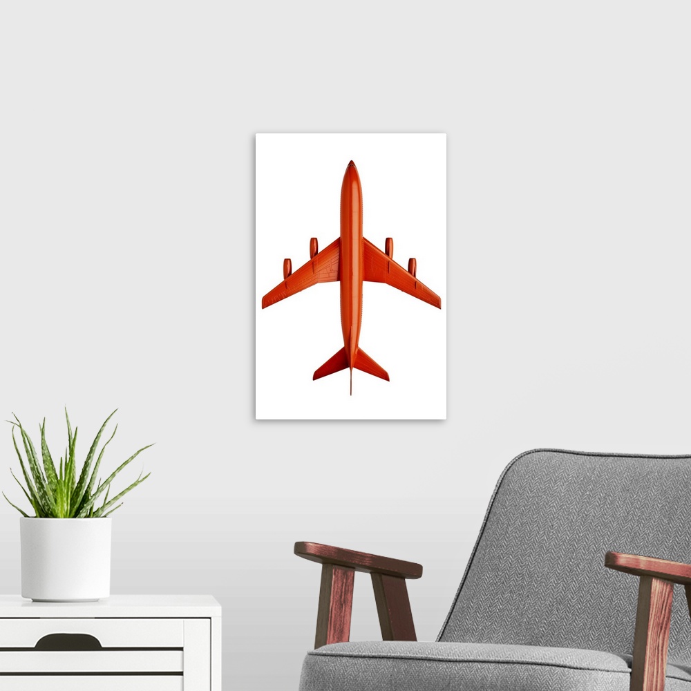 A modern room featuring Orange plastic model of an airliner / plane, on white background, cut out