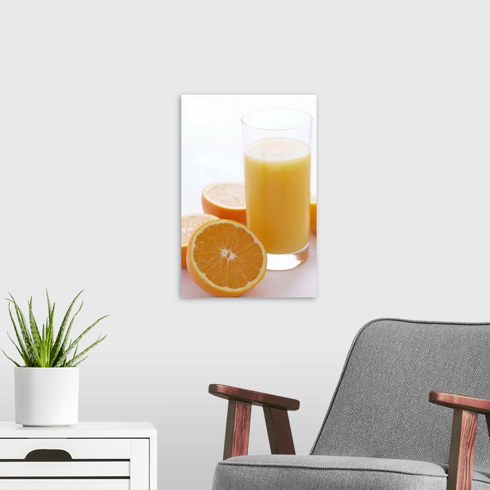A modern room featuring Oranges by orange juice in glass, close-up