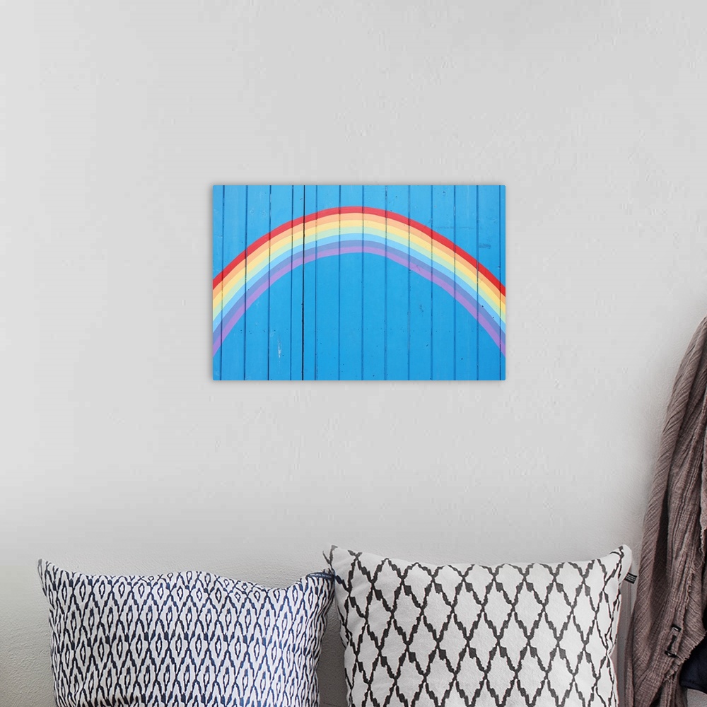 A bohemian room featuring Painted rainbow on wooden fence.