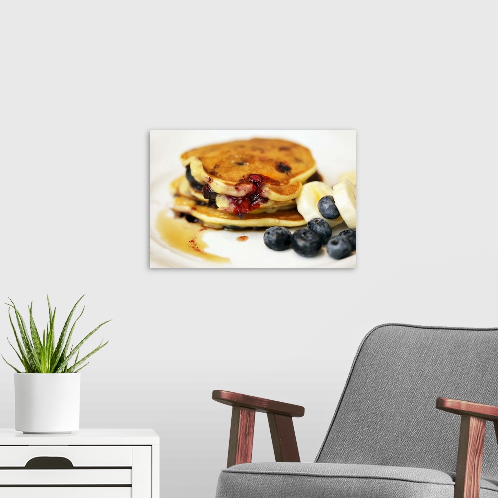 A modern room featuring Pancakes with blueberries, bananas and maple syrup