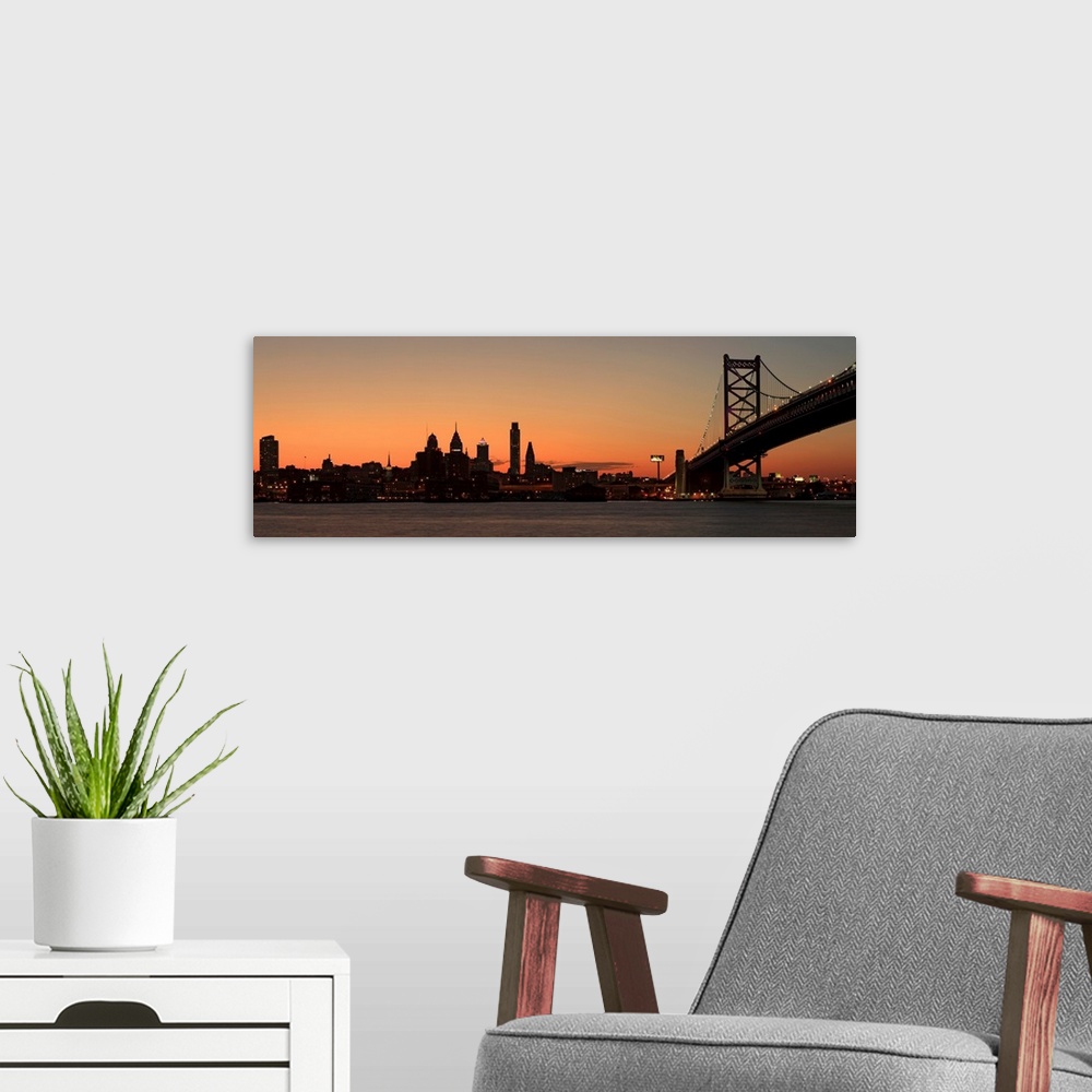 A modern room featuring Long horizontal image of the silohuette of the skyline of Philadelphia along the water front with...