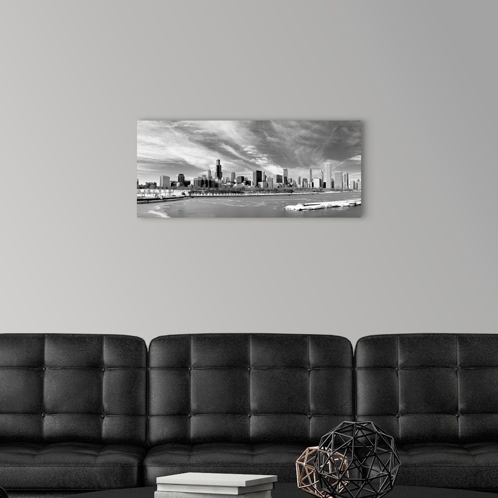 A modern room featuring Landscape photograph on a large canvas of the Chicago skyline during winter, beneath a sky of wis...