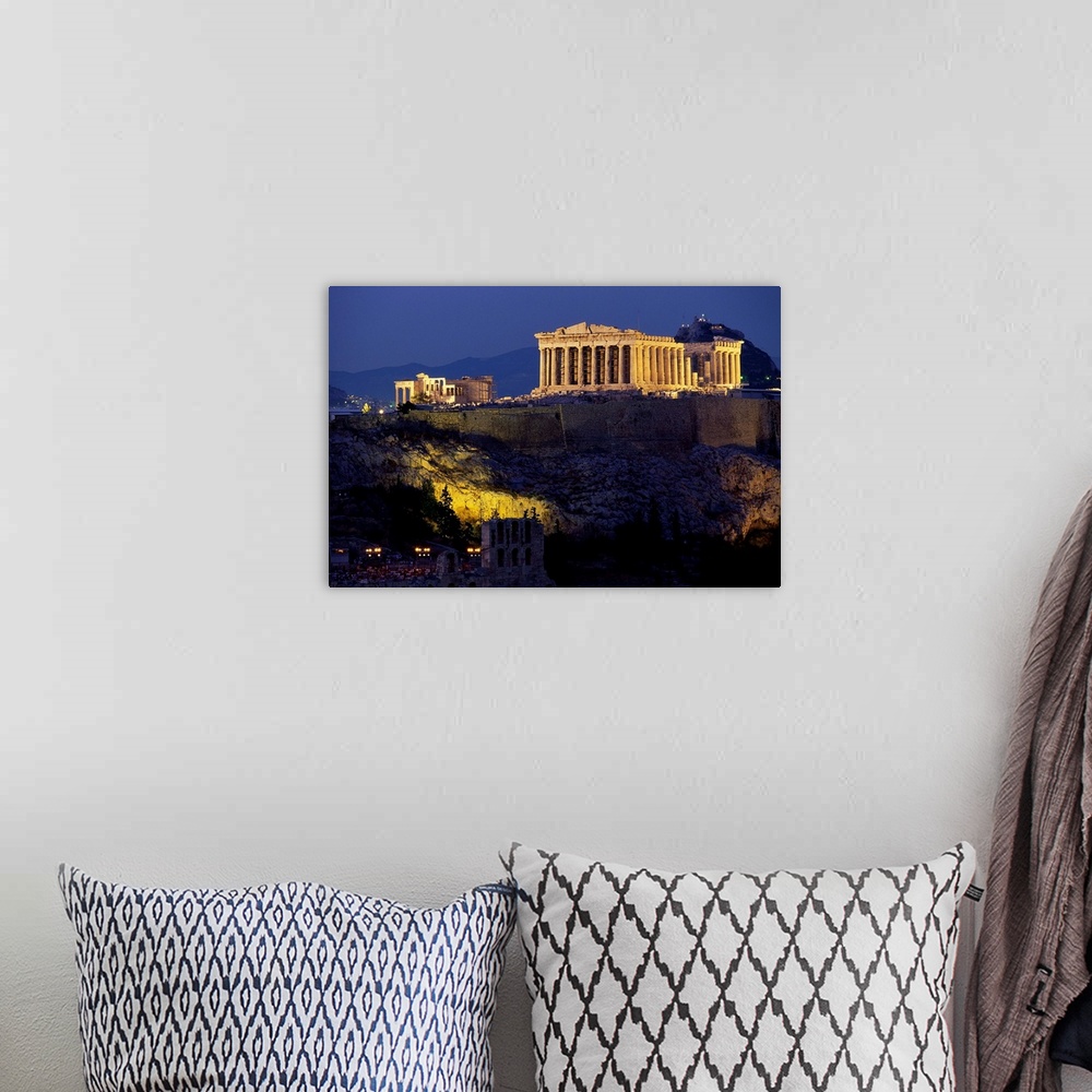 A bohemian room featuring The Parthenon and surrounding temples of the Acropolis sit illuminated, overlooking Athens.