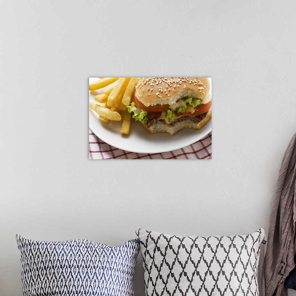 A bohemian room featuring Cheeseburger, bites taken, with chips