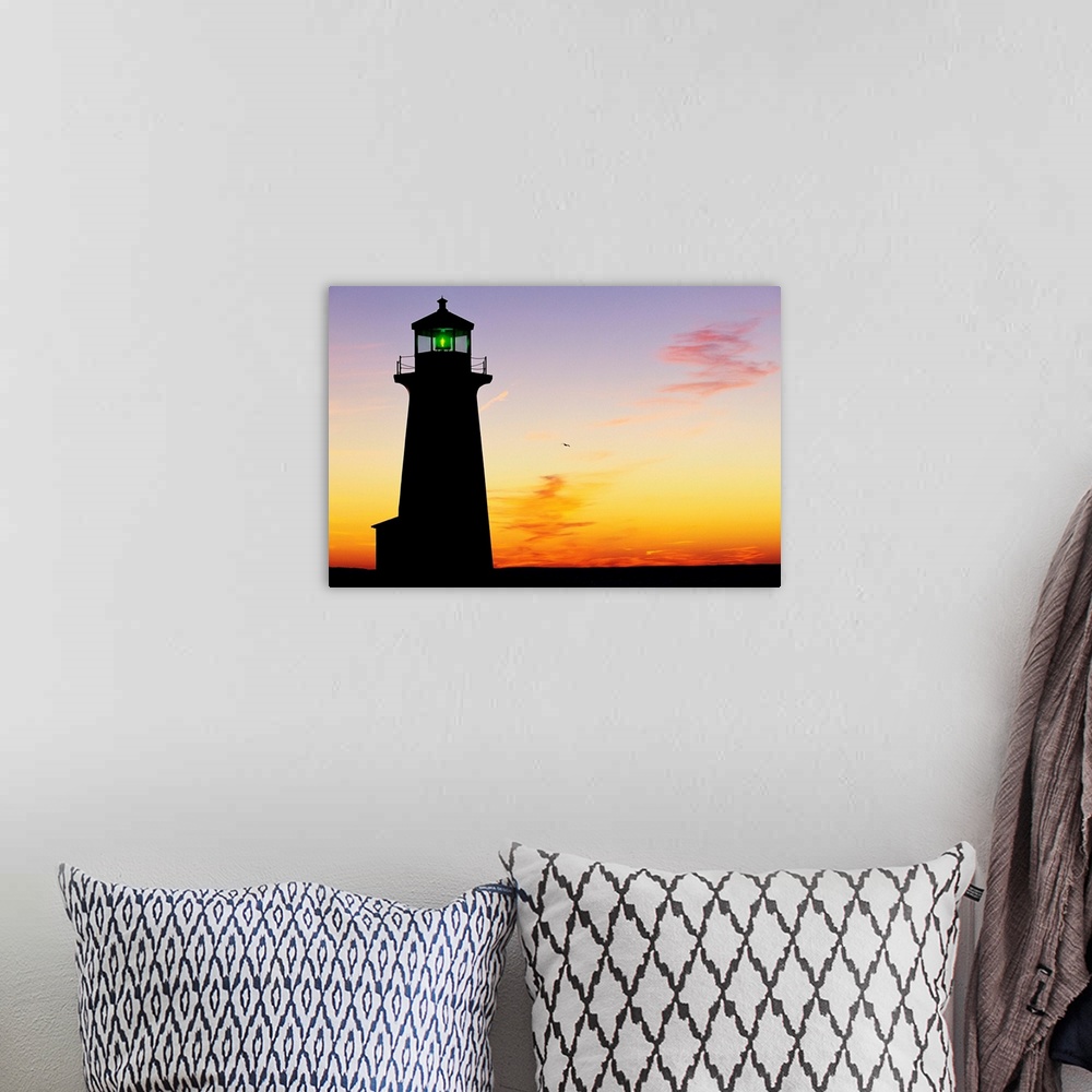 A bohemian room featuring Silhouette of Peggy's Cove Lighthouse at sunset in Nova Scotia.