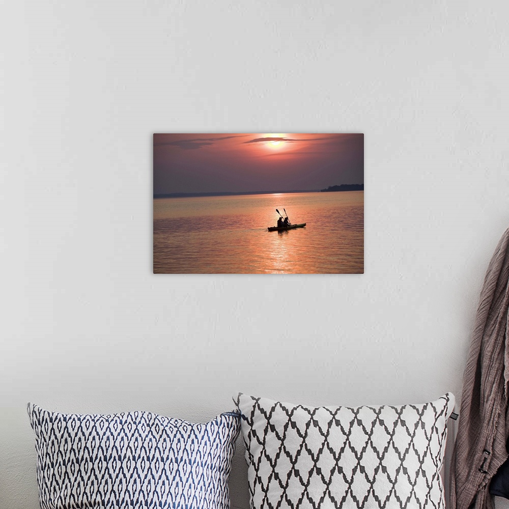 A bohemian room featuring People kayaking at sunset