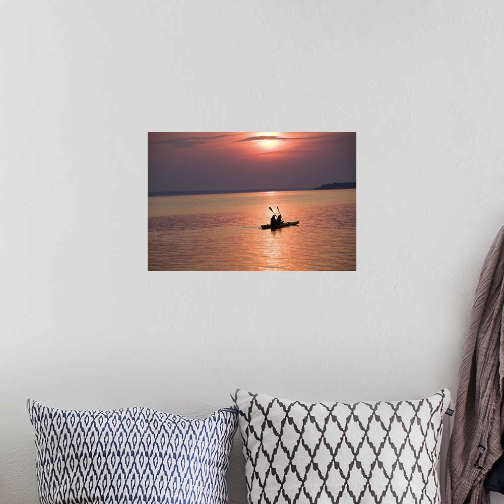 A bohemian room featuring People kayaking at sunset