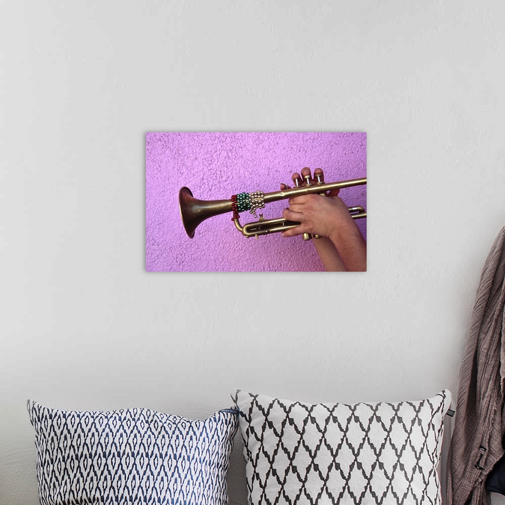 A bohemian room featuring Person playing trumpet, close-up of hands