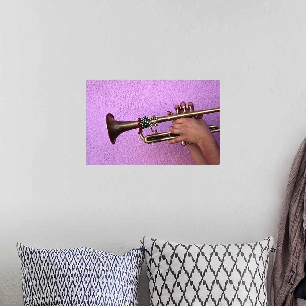 A bohemian room featuring Person playing trumpet, close-up of hands