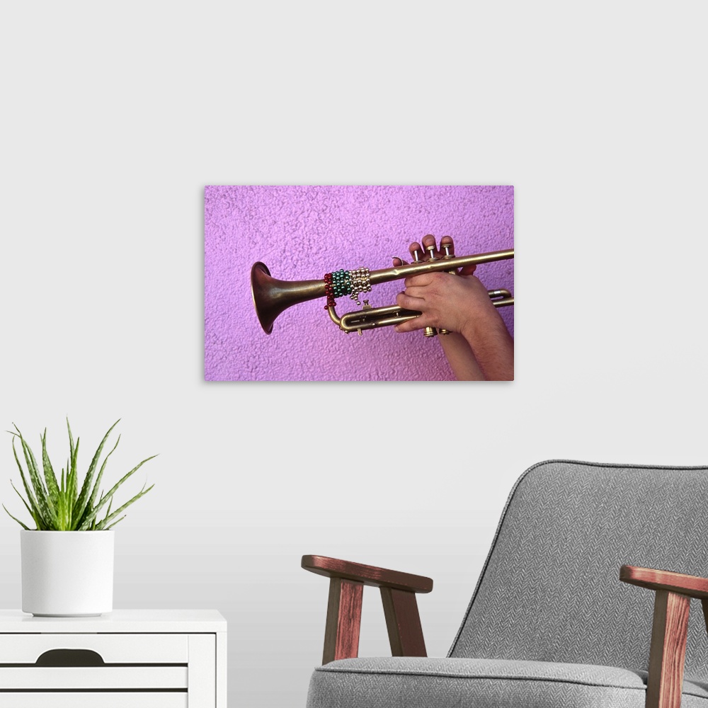 A modern room featuring Person playing trumpet, close-up of hands