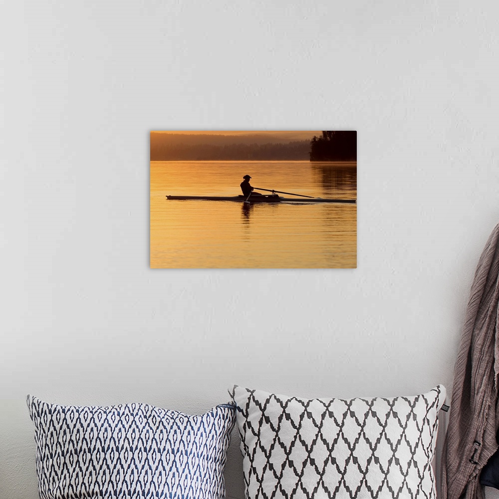A bohemian room featuring Person rowing sculling boat on river