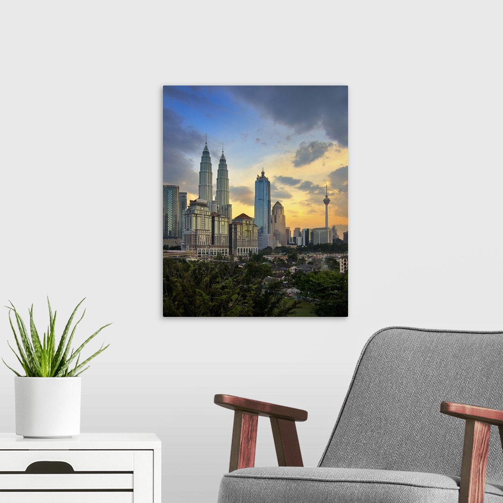 A modern room featuring Petronas twin towers at sunset.